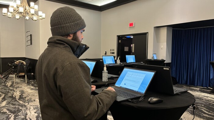 Un citoyen écrit sur le clavier d'un ordinateur portable.