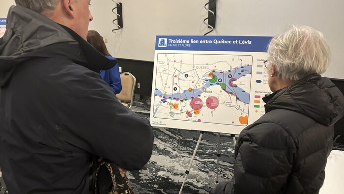 Richard Nolet et Monique Labelle regarde une pancarte du MTMD avec des informations sur les densités de population.