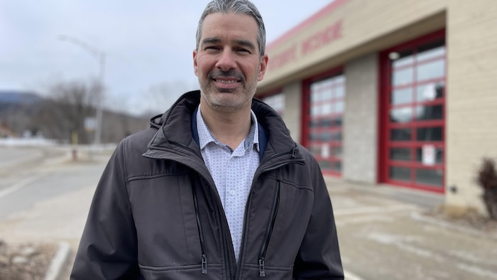 Patrick Lavoie devant une caserne de pompiers.