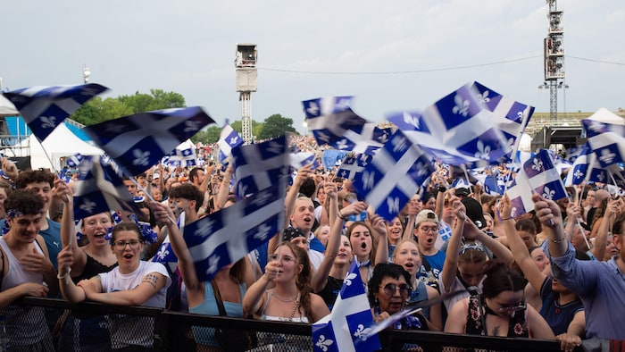 A large crowd agitates Quebec flags. national day show quebec: public