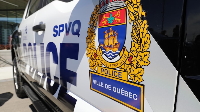 Plan rapproché des armoiries du SPVQ affichées sur un véhicule de patrouille.