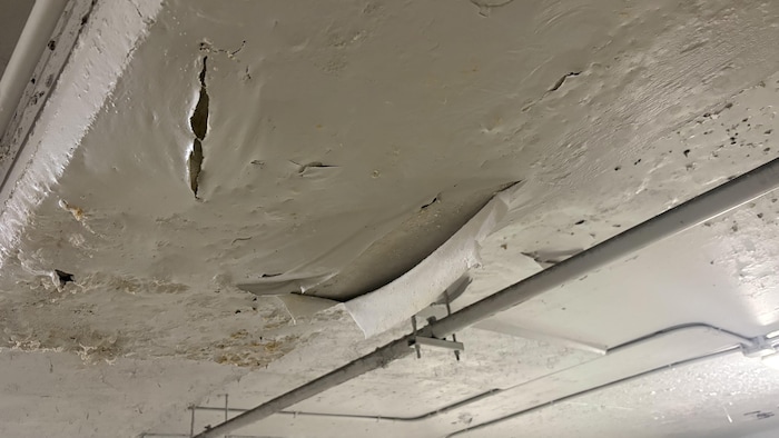 Un plafond de stationnement avec la peinture écaillée par l'eau.