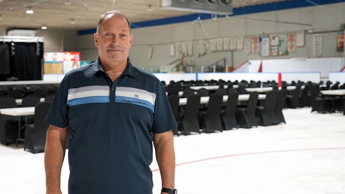 Stéphane Rioux sur la patinoire de l'aréna qui est occupée par des chaises en prévision d'un gala qui doit s'y tenir.