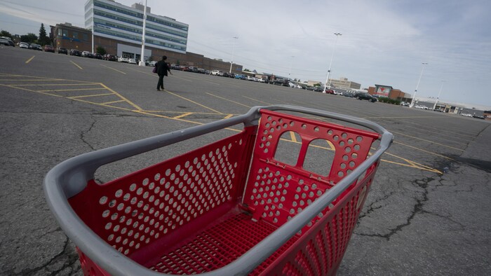 Un panier d'épicerie vide dans le stationnement d'un centre commercial.