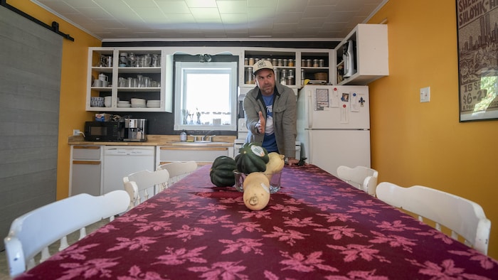 Guillaume Leblanc devant sa table de cuisine qui est exactement sur la ligne de la frontière.