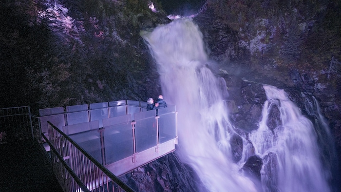 Des touristes sur l'esplanade, au dessus de la chute.