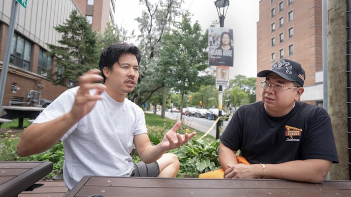 Michel Nguyen et Michel Lim devant pancartes devant l'hôpital Jean-Talon.