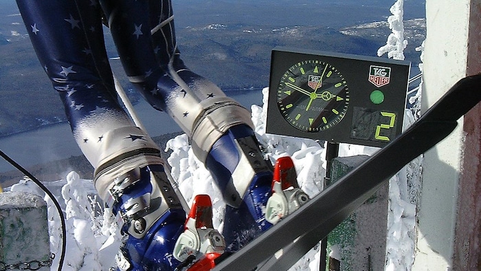 Chronomètre au sommet d'une montagne. Un skieur est sur la ligne de départ.