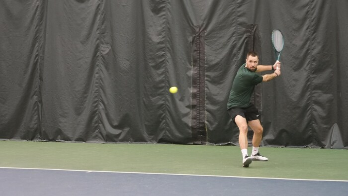 André-Michel Proulx, en train de frapper une balle de tennis.