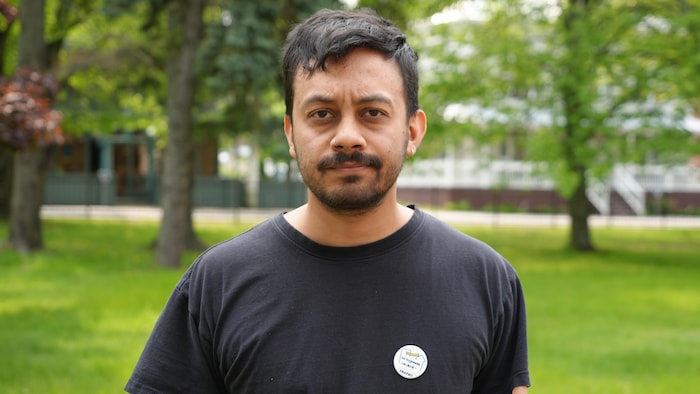 Thomas Savy, intervenant au Comité logement Bas-Saint-Laurent se tient debout dehors.