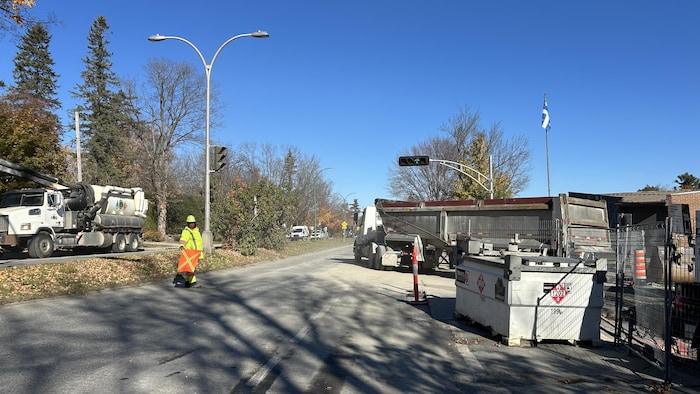Un travailleur de la construction s'occupe de diriger la circulation près du chantier de la rue Moore.