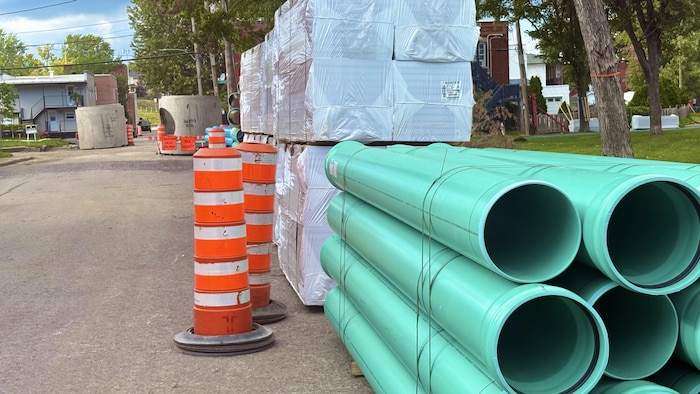 Des tuyaux empilés sur un chantier.