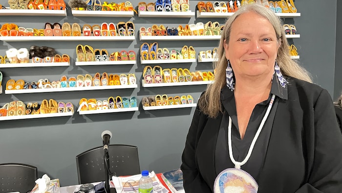 Kimberly Murray devant une murale de mocassins.