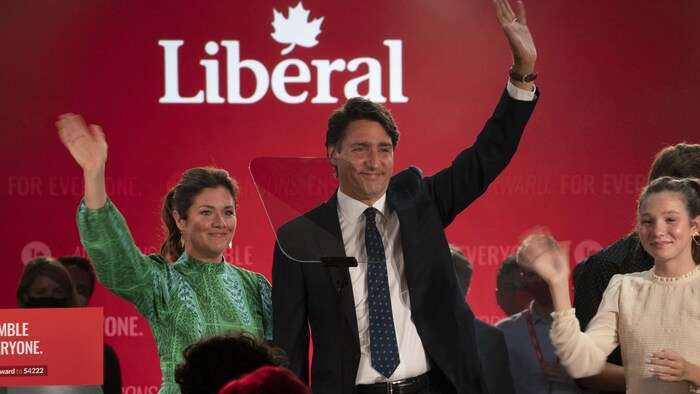 Trudeau with wife and children waving on stage with Liberal Party backdrop.