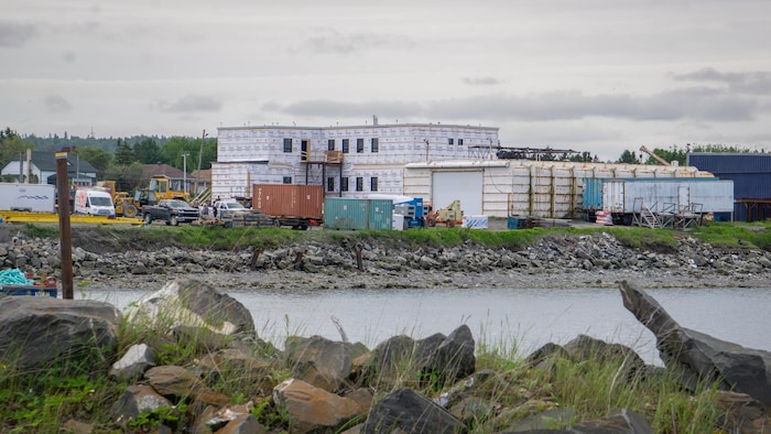 Un bâtiment de deux étages en construction sur le bord de l'eau.