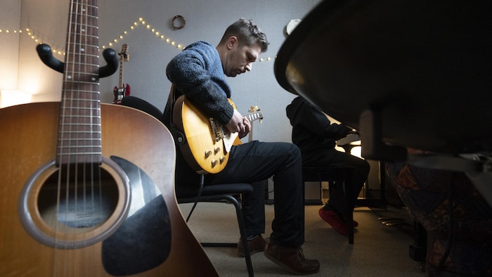 Un homme joue de la guitare.