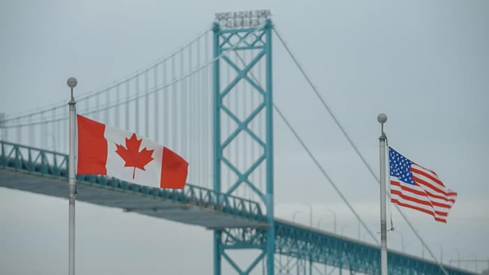 Le pont Ambassador avec un drapeau canadien et un drapeau des États-Unis à l'avant-plan.