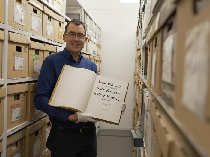 David Tremblay, archiviste à la Ville de Québec, tenant le premier livre d'or de la Ville.