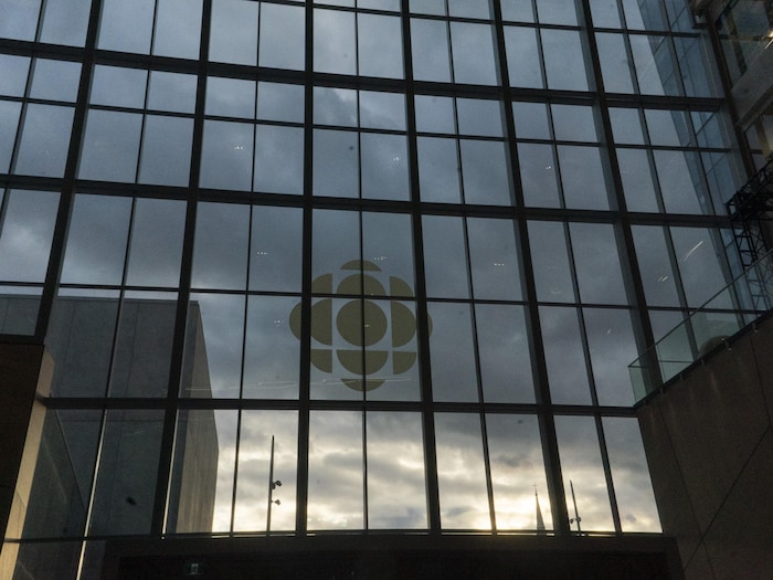 La façade de la Nouvelle maison de Radio-Canada à Montréal et le logo du diffuseur public.