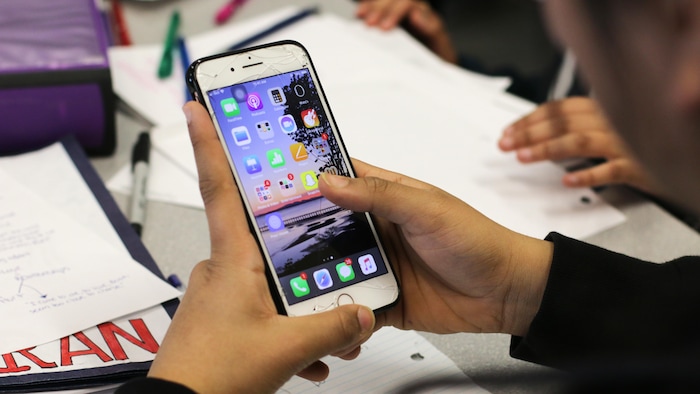 Des adolescents consultent leurs téléphones cellulaires.