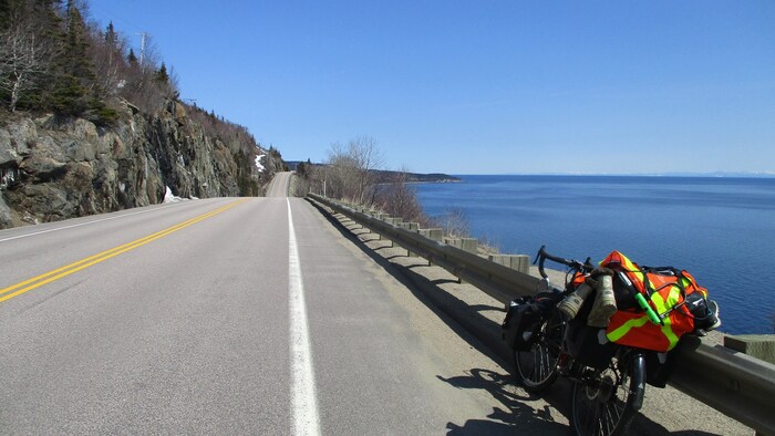 Un vélo appuyé sur un garde-fou le long de la route 138 sur la Côte-Nord.