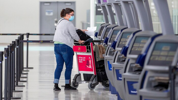 A person at the airport pushing a cart.