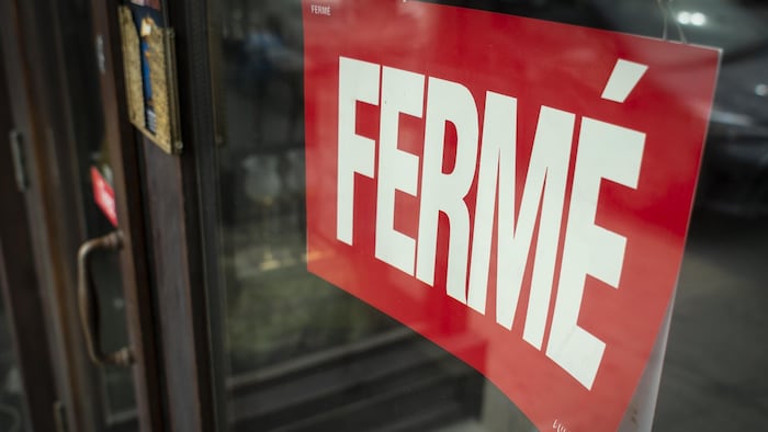 Une affiche indique qu'un commerce est fermé.
