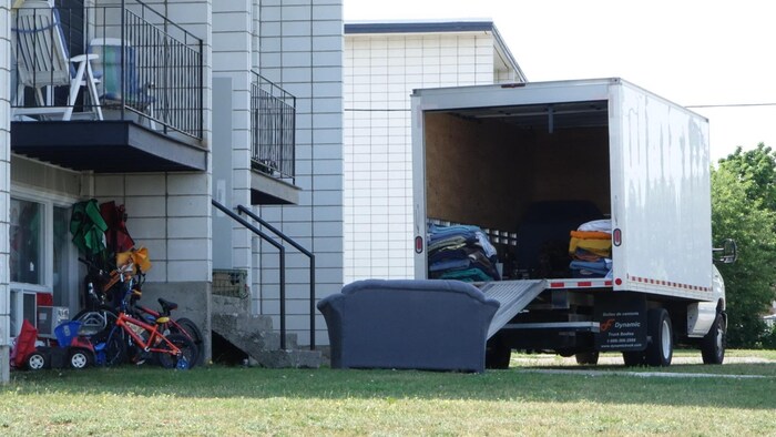 Un camion de déménagement est stationné devant un appartement.