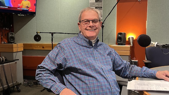 Un homme sourit à la caméra. 