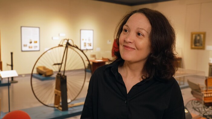 Andrée C. Godin dans le musée, souriant et regardant vers la gauche.