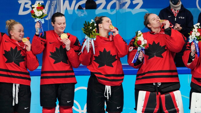 Des joueuses d'Équipe Canada embrassent la médaille d'or qu'elles portent autour du cou après avoir battu les États-Unis lors du match de hockey féminin aux Jeux olympiques d'hiver de Pékin, le jeudi 17 février 2022.