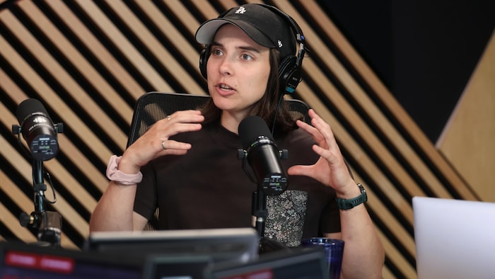 Elle est assise en studio et devant un micro.