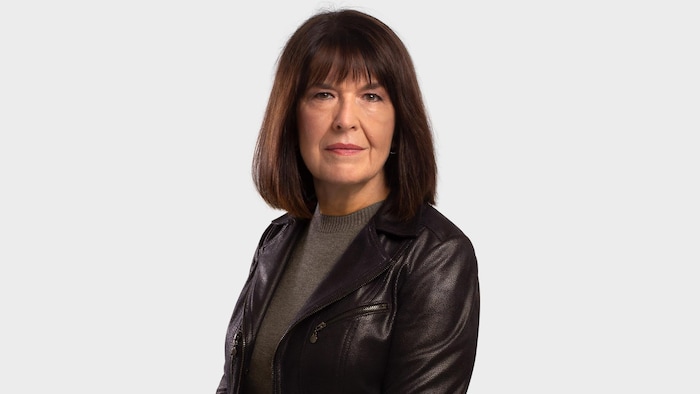 Elle prend la pose et sourit légèrement.