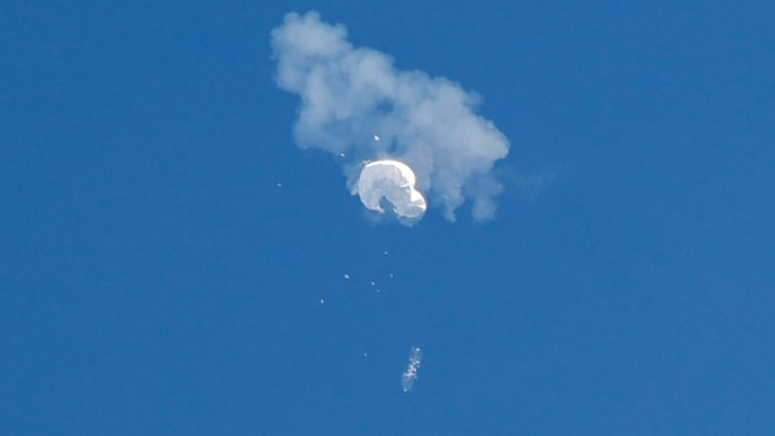 منطاد أبيض مجهز بألواح شمسية يسقط من السماء بعد انفجاره.