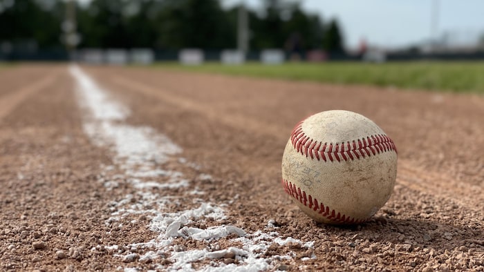Une balle de baseball repose sur un terrain.