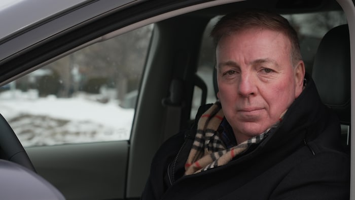 Benoît Charette assis dans sa voiture.