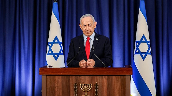 Le premier ministre israélien, Benyamin Nétanyahou, se tient derrière un bureau.