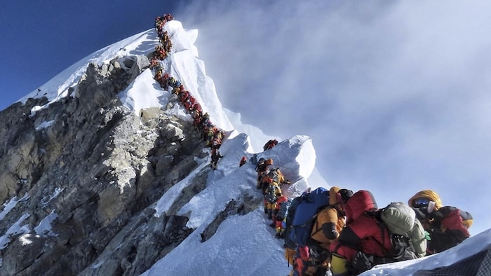 De nombreux alpinistes font la file avant d'atteindre le sommet de l'Everest.