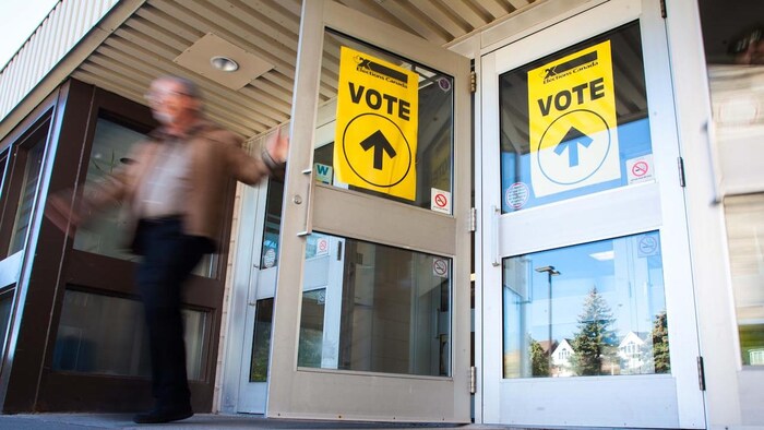 Un homme sortant d'un bureau de vote.