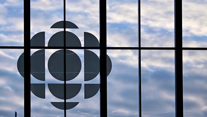 Gros plan du logo de Radio-Canada sur le mur de verre de la Nouvelle Maison de Radio-Canada. 