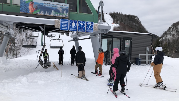 Quelques skieurs attendent pour monter à bord du télésiège.