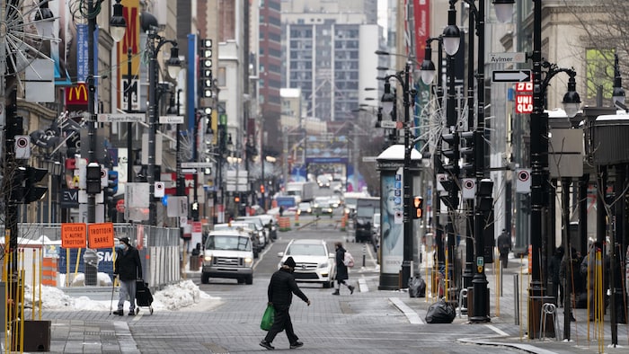 A man crosses Sainte-Catherine Street in Montreal. 