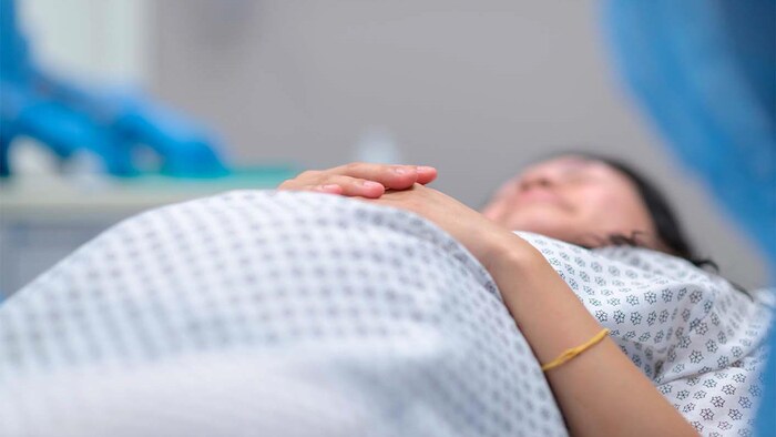 Une femme enceinte allongée sur une table d'opération.