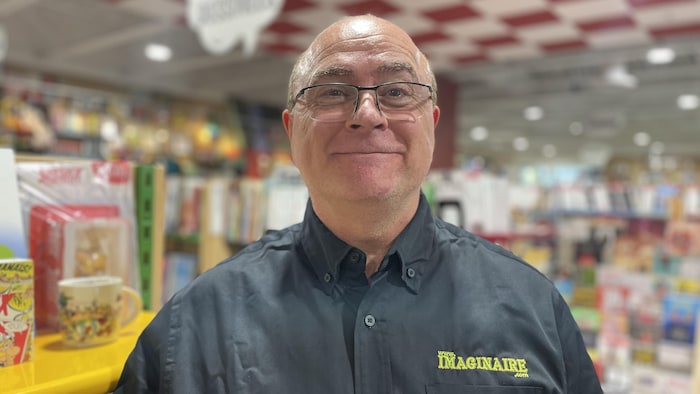 Un homme sourit dans un magasin de jeux.