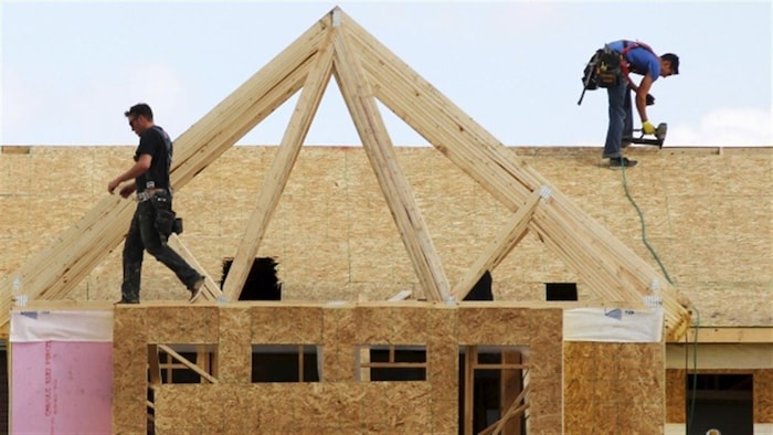 Des travailleurs de la construction bâtissent une maison à Calgary en 2015.