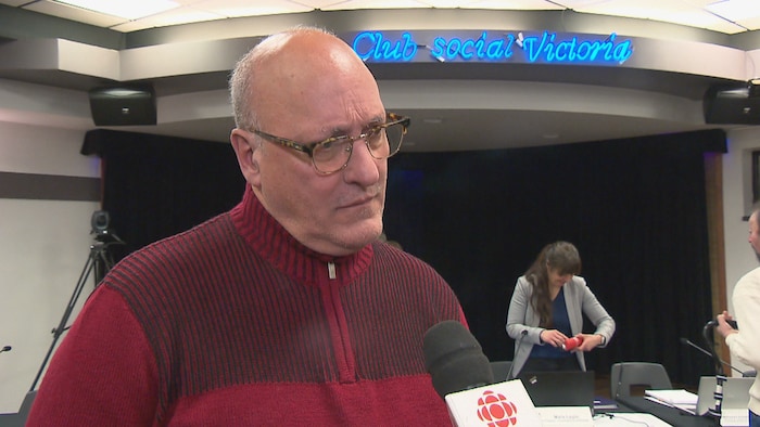 Un homme parle au micro suite à la consultation publique.
