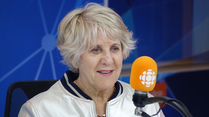 Denise Bombardier devant un micro dans un studio radio de Radio-Canada.