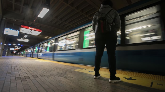 Une personne attend sur un quai de métro à Montréal.
