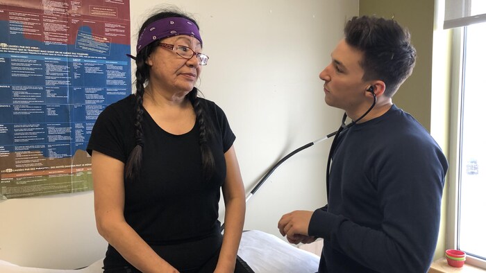 Un médecin examine une femme autochtone.