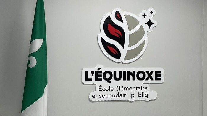 Couloir d'école avec le logo de L'Équinoxe et un drapeau franco-ontarien.